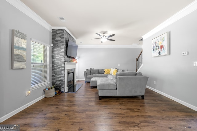 living room with ceiling fan, crown molding, baseboards, a fireplace, and dark wood-style flooring