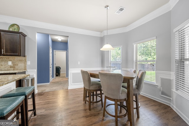 dining space featuring dark wood finished floors, crown molding, and visible vents