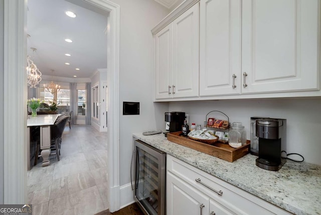 bar with recessed lighting, ornamental molding, wine cooler, and a chandelier