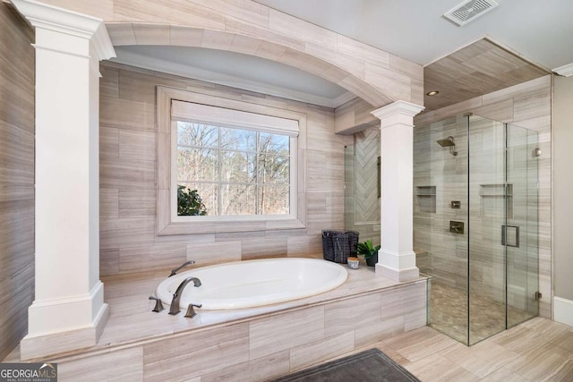 full bathroom featuring visible vents, crown molding, decorative columns, a bath, and a stall shower