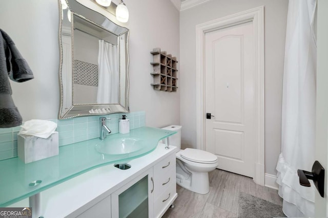 full bath with vanity, decorative backsplash, crown molding, and toilet