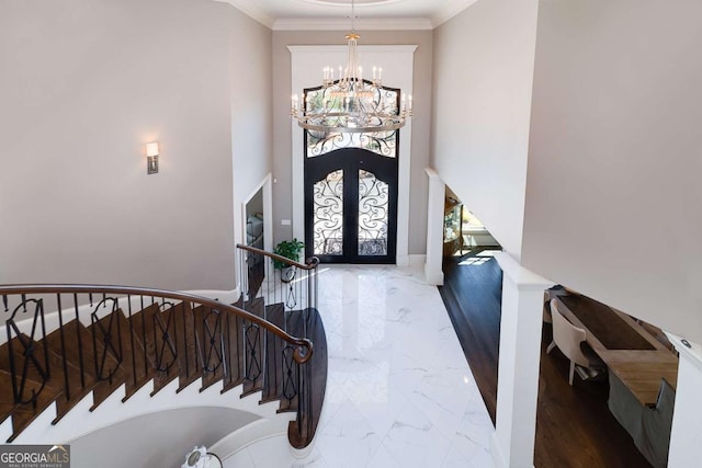 foyer featuring stairs, marble finish floor, a high ceiling, a chandelier, and french doors