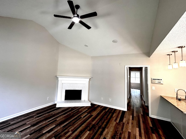 1864 Drew Cir, Austell, GA 30168 - unfurnished living room featuring lofted ceiling, a ceiling fan, dark wood finished floors, and a brick fireplace