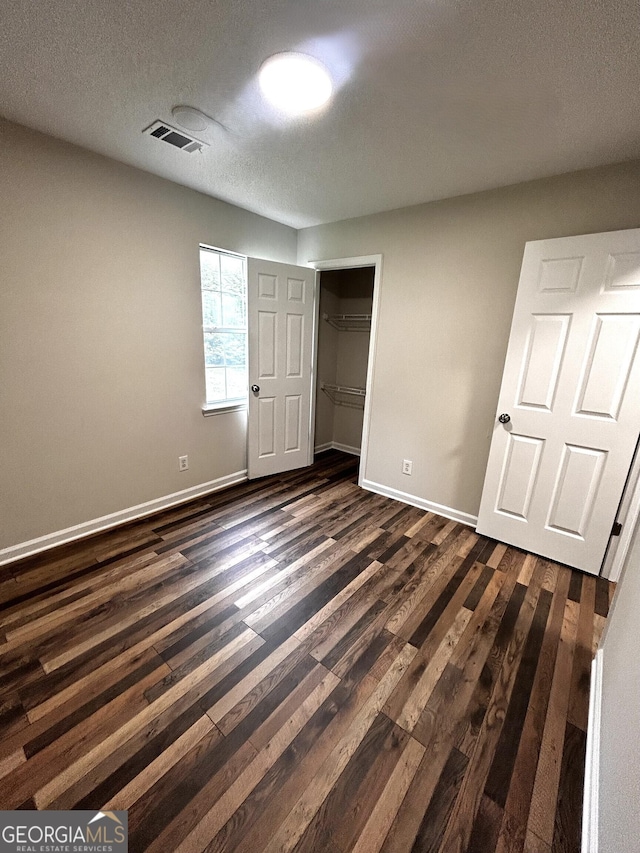 1864 Drew Cir, Austell, GA 30168 - unfurnished bedroom with dark wood-type flooring, a textured ceiling, and a closet