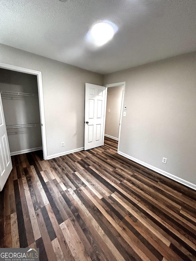 1864 Drew Cir, Austell, GA 30168 - unfurnished bedroom with dark wood-type flooring, a closet, and a textured ceiling
