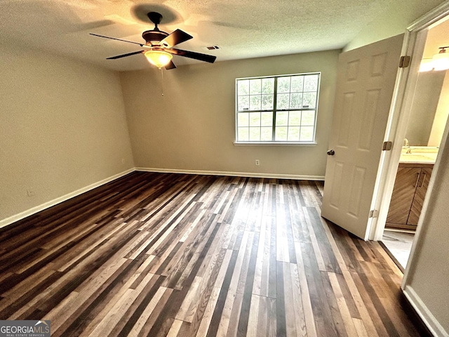 1864 Drew Cir, Austell, GA 30168 - unfurnished bedroom with a textured ceiling, dark wood-type flooring, ceiling fan, and connected bathroom