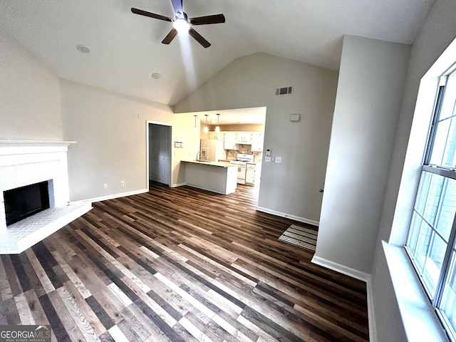 1864 Drew Cir, Austell, GA 30168 - unfurnished living room featuring ceiling fan, vaulted ceiling, dark wood-style flooring, and a fireplace
