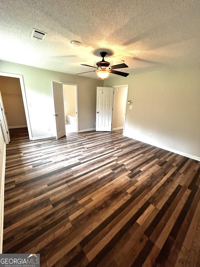 1864 Drew Cir, Austell, GA 30168 - unfurnished bedroom featuring dark wood finished floors, a textured ceiling, connected bathroom, and a ceiling fan
