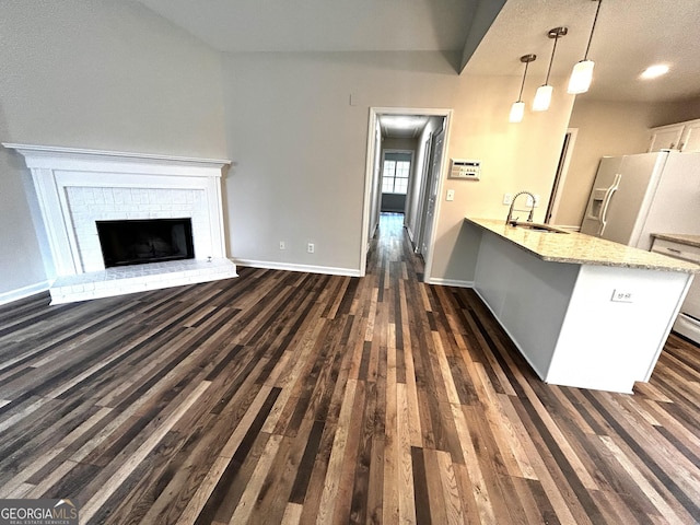 1864 Drew Cir, Austell, GA 30168 - kitchen with white fridge with ice dispenser, dark wood finished floors, a peninsula, pendant lighting, and light stone counters