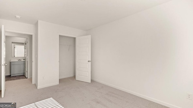 unfurnished bedroom with a closet, baseboards, and light colored carpet