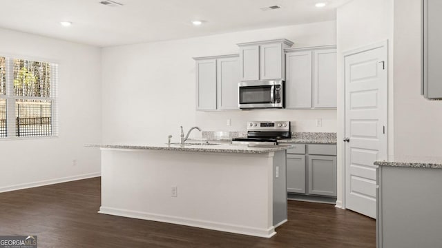 kitchen featuring gray cabinets, dark wood-type flooring, visible vents, appliances with stainless steel finishes, and a sink