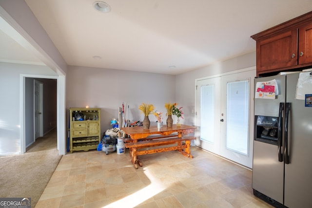 kitchen with stainless steel fridge and light colored carpet