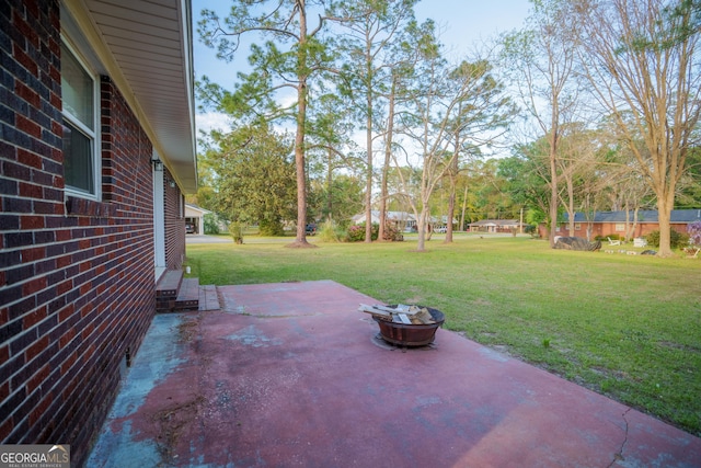 view of yard featuring a fire pit and a patio area