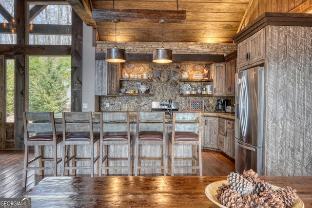 1329 Grandeur Dr, Blue Ridge, GA 30513 - kitchen with vaulted ceiling, open shelves, stainless steel fridge with ice dispenser, dark wood finished floors, and decorative light fixtures