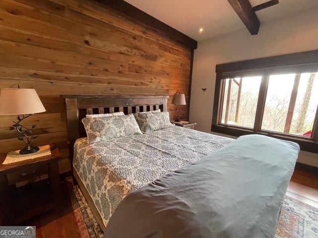 1329 Grandeur Dr, Blue Ridge, GA 30513 - bedroom featuring beamed ceiling, wood finished floors, and wood walls