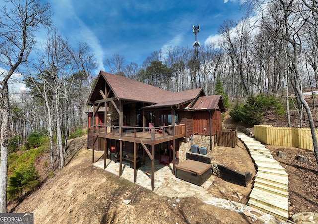 1329 Grandeur Dr, Blue Ridge, GA 30513 - rear view of house with stone siding, a wooden deck, a patio, stairs, and roof with shingles