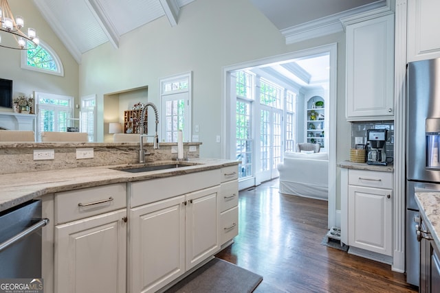 kitchen with dark wood-type flooring, appliances with stainless steel finishes, open floor plan, and a sink