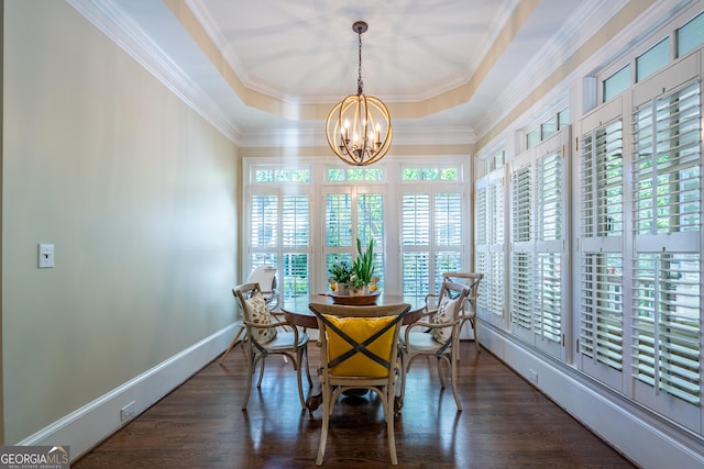 dining space with baseboards, a notable chandelier, wood finished floors, crown molding, and a raised ceiling