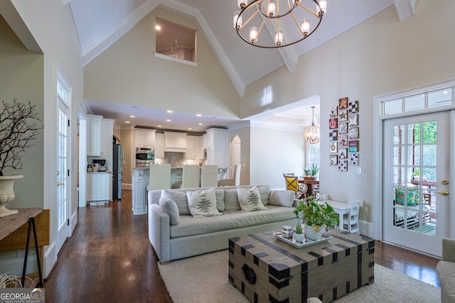 living room with dark wood-style floors, high vaulted ceiling, and an inviting chandelier