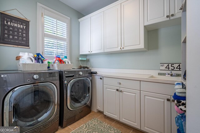 laundry area with washing machine and dryer, light tile patterned floors, cabinet space, and a sink