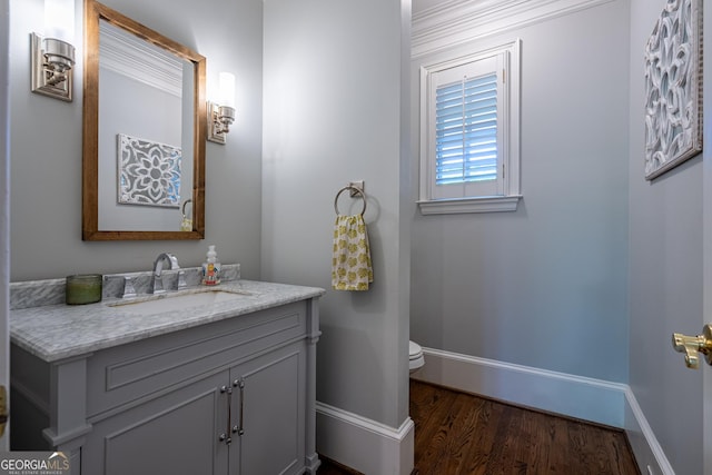 bathroom featuring wood finished floors, vanity, toilet, and baseboards