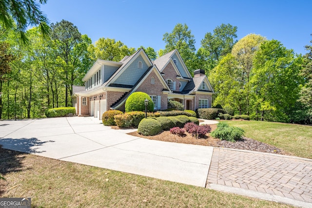 view of front of home featuring brick siding, a front lawn, driveway, and an attached garage
