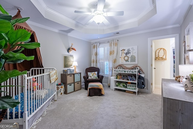 carpeted bedroom with visible vents, ceiling fan, ornamental molding, and a raised ceiling