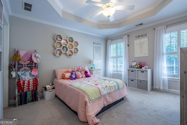 bedroom featuring light carpet, a tray ceiling, and visible vents