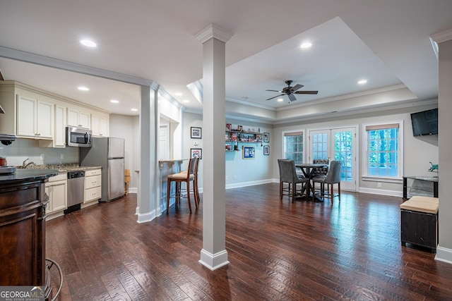 dining space with a ceiling fan, baseboards, dark wood finished floors, and crown molding