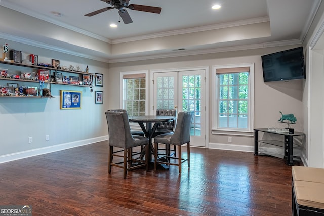 dining space with dark wood-style floors, a tray ceiling, a ceiling fan, ornamental molding, and baseboards