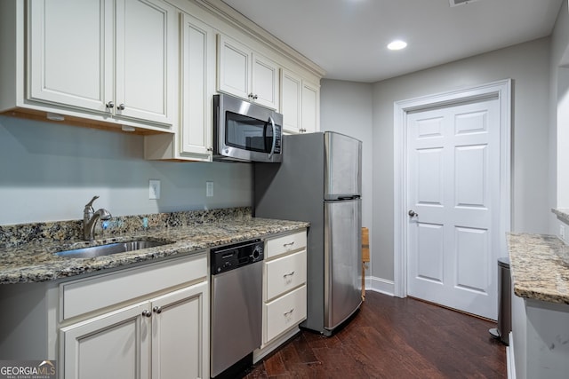 kitchen featuring dark wood-style flooring, appliances with stainless steel finishes, a sink, and white cabinetry