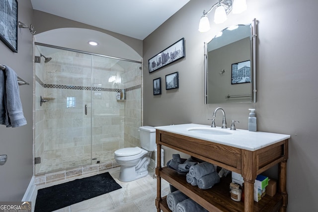 bathroom with a shower stall, toilet, and vanity