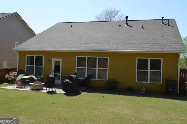 rear view of property featuring an outdoor fire pit, fence, a patio, and a lawn