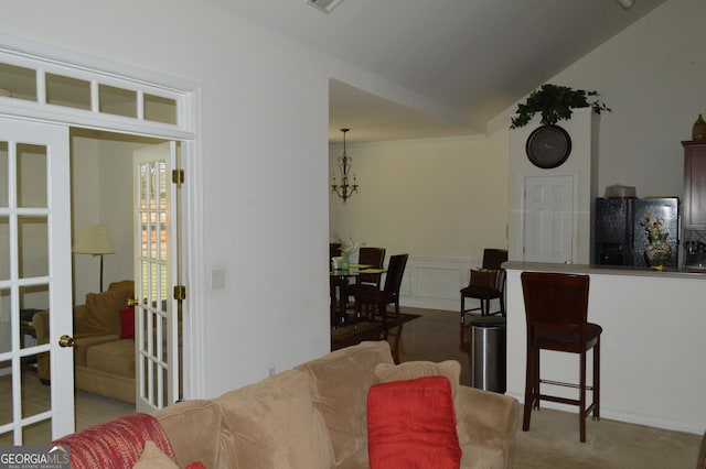 living room featuring visible vents, vaulted ceiling, a wainscoted wall, carpet flooring, and french doors