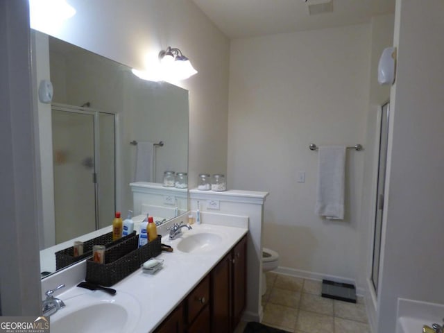 full bath with toilet, a stall shower, a sink, and tile patterned floors