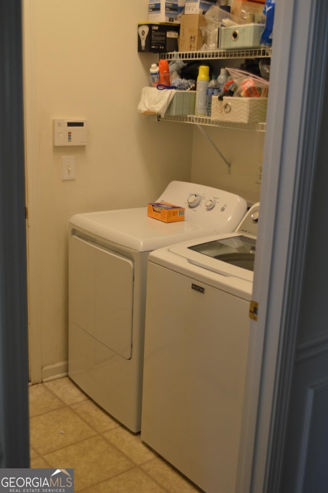 laundry room featuring washer and dryer, light tile patterned floors, and laundry area