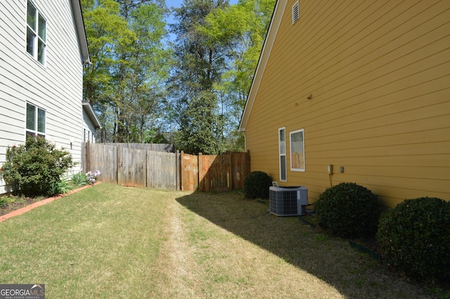 view of yard featuring central air condition unit and fence