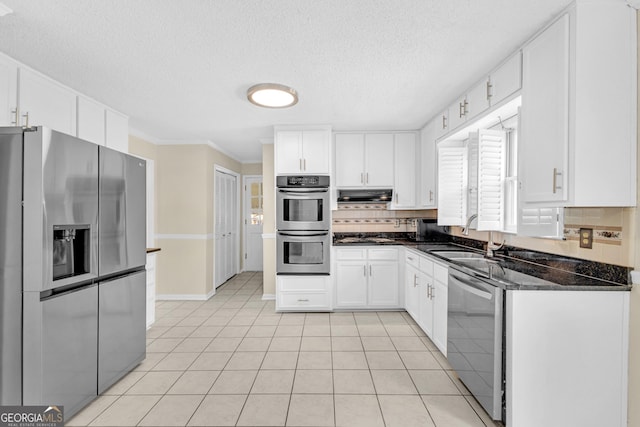 kitchen with stainless steel appliances, a sink, decorative backsplash, white cabinetry, and ventilation hood