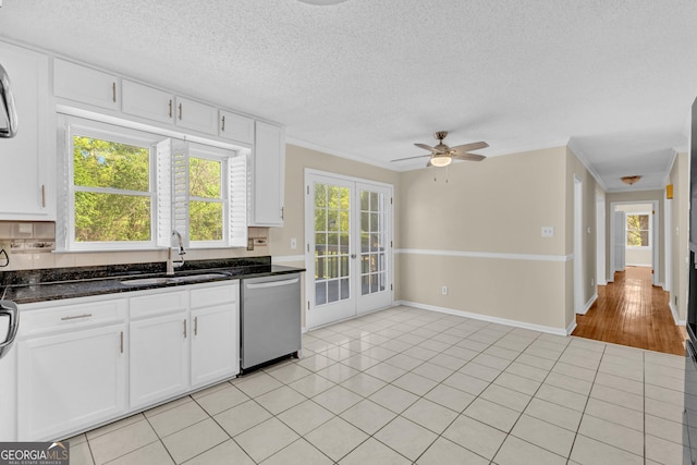 kitchen featuring dishwasher, a sink, french doors, white cabinets, and dark stone counters