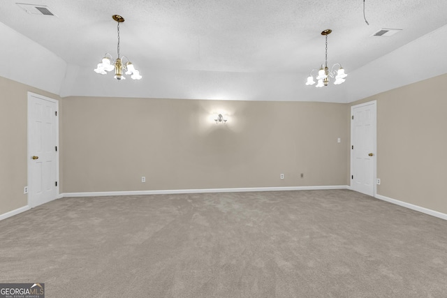 empty room with a chandelier, lofted ceiling, carpet, baseboards, and a textured ceiling