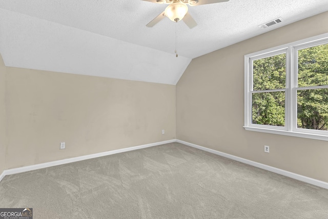bonus room featuring baseboards, carpet floors, a ceiling fan, lofted ceiling, and a textured ceiling