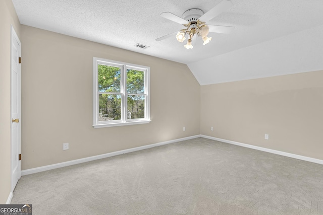 additional living space with ceiling fan, carpet, baseboards, lofted ceiling, and a textured ceiling