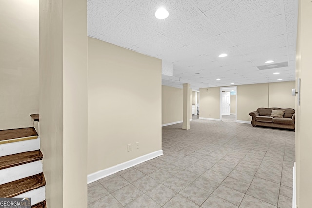 finished below grade area featuring stairway, baseboards, and recessed lighting