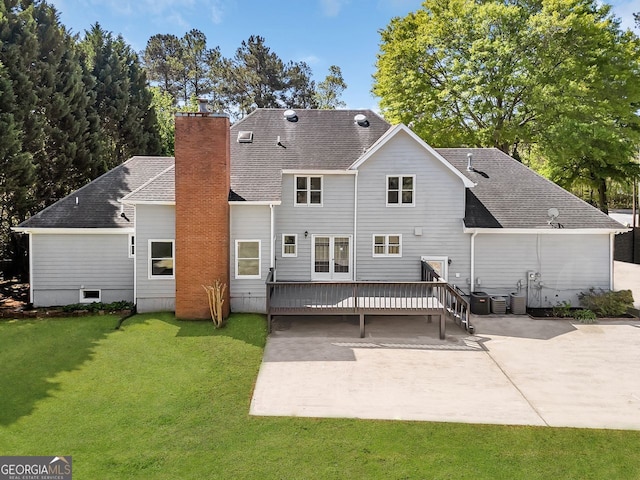 rear view of property featuring a patio, a wooden deck, a lawn, and a chimney