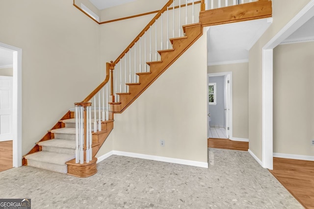 stairs with crown molding and baseboards