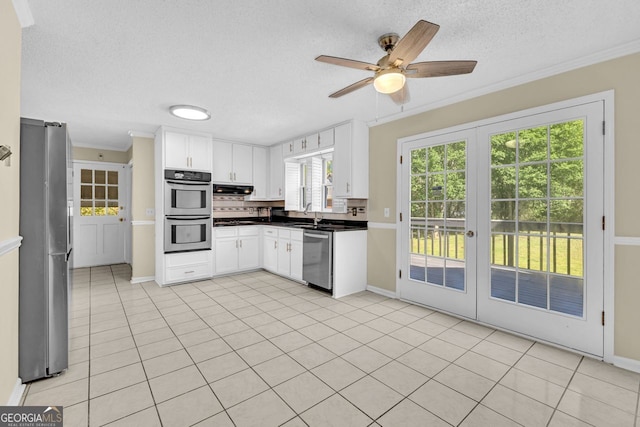 kitchen with appliances with stainless steel finishes, a textured ceiling, ceiling fan, white cabinetry, and crown molding