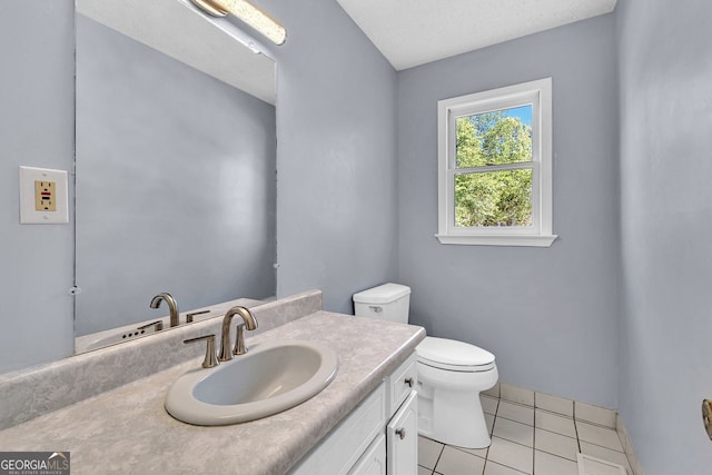 half bath featuring tile patterned floors, toilet, and vanity