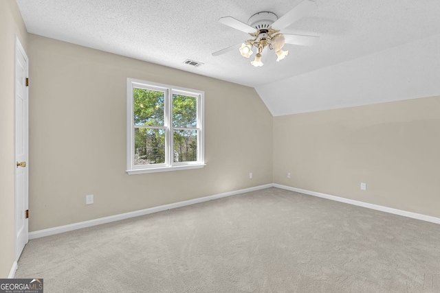 additional living space with a ceiling fan, carpet floors, baseboards, a textured ceiling, and lofted ceiling