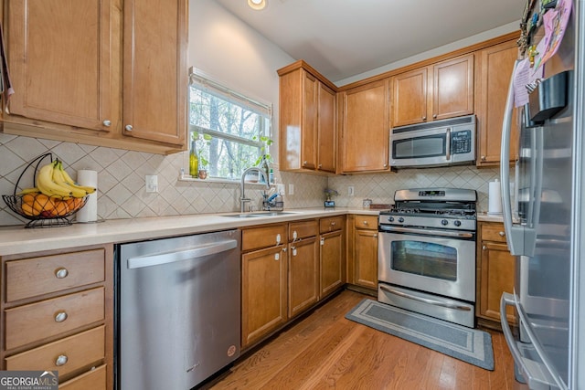 2705 Maple Park Pl Unit 29, Cumming, GA 30041 - kitchen featuring light countertops, a sink, wood finished floors, and appliances with stainless steel finishes