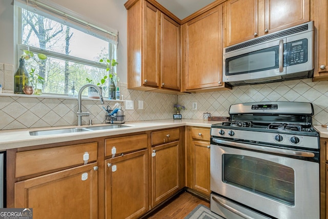 2705 Maple Park Pl Unit 29, Cumming, GA 30041 - kitchen featuring light countertops, a sink, stainless steel appliances, and brown cabinetry